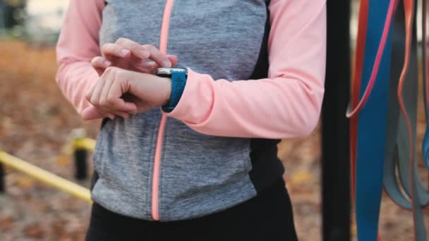 健身女孩检查智能手表锻炼的进展情况 有脉搏跟踪器的女运动员 — 图库视频影像