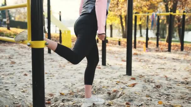 健身女孩在室外做腿部和臀部运动 秋日公园里 一名年轻女子在积极地进行隆重运动 — 图库视频影像