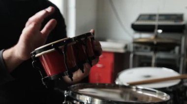 Kayıt stüdyosunda bongo çalan adam elleri. Geleneksel etnik müzik enstrümanları olan adam.