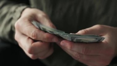 Man counting american dollars banknotes in hands