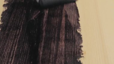 Coloring with varnish impregnat varnish impregnat of wooden table using roller brush. Brown color painting or varnishing wooden surface. House and furniture renovation.