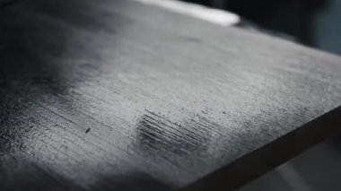 Black color painting surface of wooden table using roller brush. House and furniture renovation.