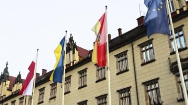 Poland, Ukraine and Europe Union flags in Wroclaw city next to old building facade. National symbols in historical downtown in EU
