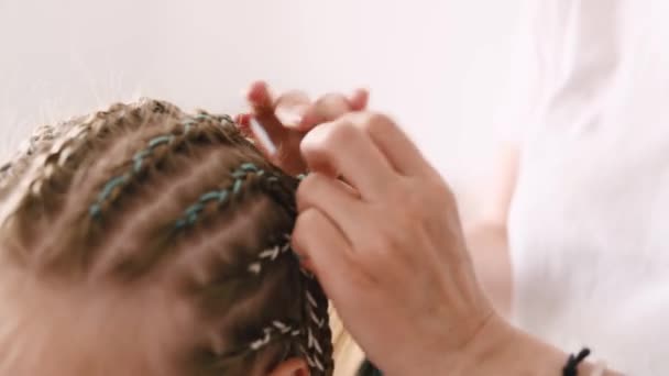 理发师为小女孩做辫子式的辫子 儿童特写时新染发时的理发师手 — 图库视频影像