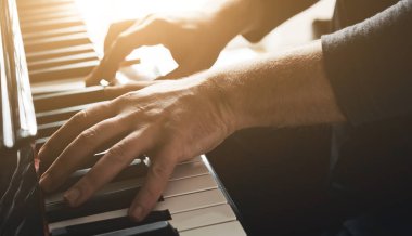 Man hands playing piano keyboard closeup and creating instrumental composition with professional sound. Musician perfomance with classical music on pianoforte