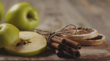 Tahtada duran tarçın çubuklarının yanında yuvarlak elma dilimleri