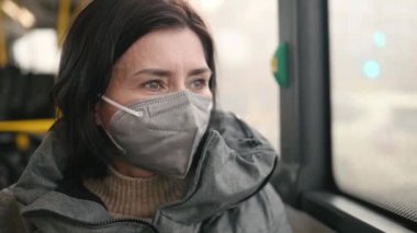 Woman rides a bus wearing protective face mask due quarantine. Pandemia covid-19 protective measures.
