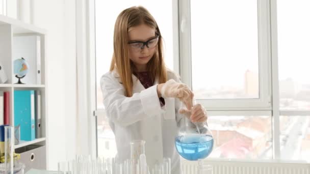 Uczennica Nosząca Okulary Ochronne Butelką Wypełnioną Niebieskim Płynem Klasie Chemicznej — Wideo stockowe
