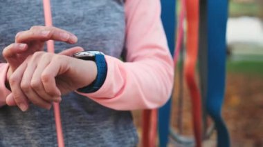 Fitness kızı akıllı saat egzersizlerini kontrol ediyor. Puls izleyicili spor kadın yakın plan.