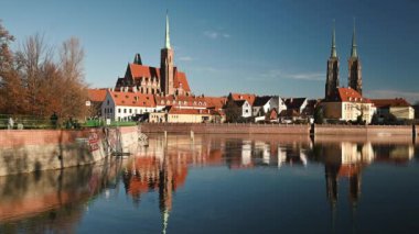 Polonya 'nın Wroclaw şehrindeki kalenin ve nehrin ortaçağ mimarisi, kırmızı çatılı tarihi binalara bakıyor. Avrupa 'nın manzaralı eski kasabası