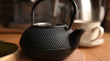 El, sıcak içecek hazırlamak için mutfakta çaydanlığa siyah çay koyar. Su ısıtıcısında sağlıklı bir içecek.