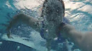 Güzel bir genç kız su altında kabarcıklarla yüzüyor. Mavi suya dalan güzel bir kadın.