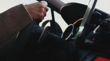 Direksiyonda kadın eller, yolda araba süren kadın, ağır çekimde. Akıllı telefondan GPS navigasyonu kullanılıyor.