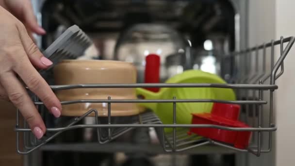女孩手把五颜六色的碗碟放在厨房洗碗机上 洗衣机中的妇女和器皿帮工 慢动作 — 图库视频影像