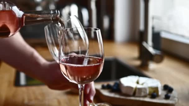 キッチンのボトルからグラスにワインを注ぐ男の手 透明ワイングラスとソムリエがアルコール飲料で満たします — ストック動画