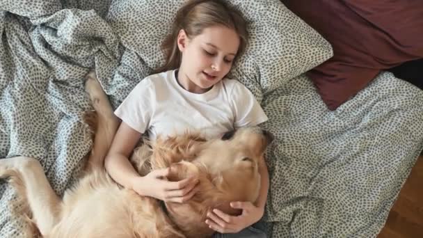 Aranyos Gyermek Lány Ölelés Golden Retriever Kutya Fekszik Ágyban Beszél — Stock videók