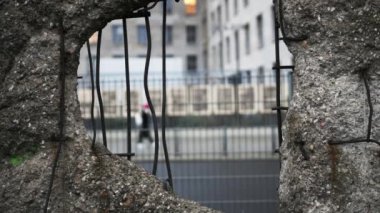 Hole in Broken Berlin wall and walking person against. Concept of freedom and independence.