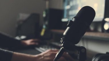 Kayıt stüdyosundaki mikrofon yakın çekim ve ses karıştırıcı ekipmanla insan eli. Müzik prodüksiyon sürecinde yayınlar için mikrofon