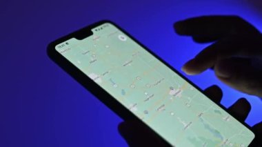 Poznan, Polonya - 13 Ocak: Google Maps uygulaması kullanan kız mavi arkaplana karşı akıllı telefon kullanıyor, görüntüyü kapat