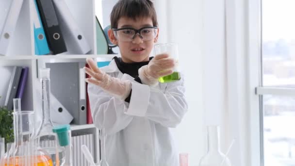 Uczeń Lekcji Chemii Nosi Okulary Ochronne Patrząc Butelkę Zielonym Płynem — Wideo stockowe