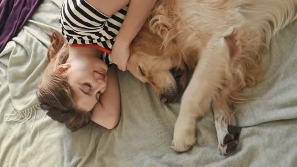 Vertikales Video Von Hübschen Mädchen Umarmt Golden Retriever Hund Bett — Stockvideo