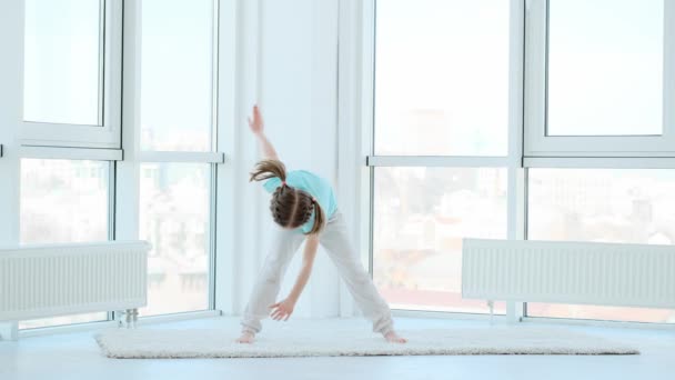 Αθλητικό Κοριτσάκι Που Εκτελεί Την Άσκηση Ανεμόμυλων Στο Σπίτι — Αρχείο Βίντεο