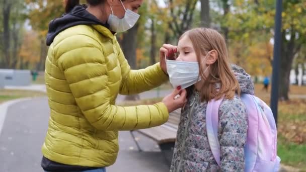 Mãe Colocando Máscara Protetora Filha Enquanto Vai Escola Através Parque — Vídeo de Stock