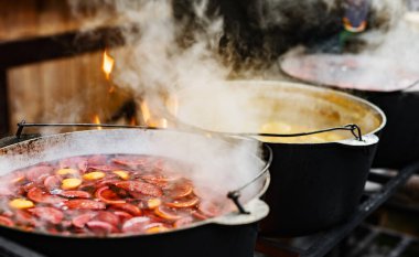 Meyve ve böğürtlen içecekler, sıcak sıcak şarap, tencerelerde pişmiş buharlı sokak yemekleri. Açık hava festivalinde renkli, sıcak, tatlı içecekler.