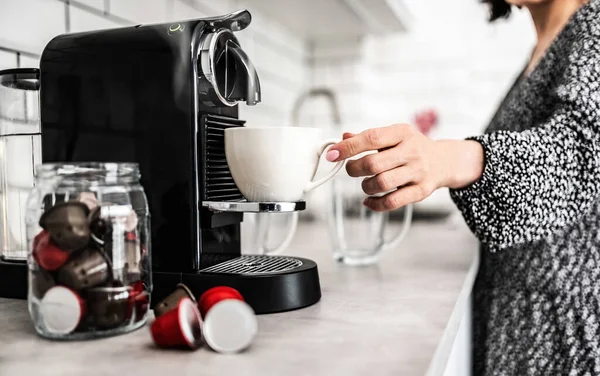 自宅のカプセルコーヒーマシンで準備エスプレッソカップを持つ女の子 イタリアのカフェイン飲料を作る女性 — ストック写真