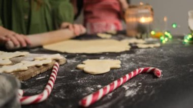 Kız ev yapımı zencefilli çörek ve ön planda noel şekeri kamışı için hamur topluyor.