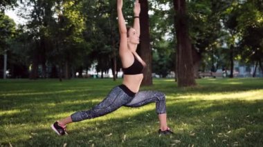 Yaz doğa parkında yoga pozunda duran genç bir kız. Kadın, sabah güneşiyle dışarıda egzersiz yapıyor.