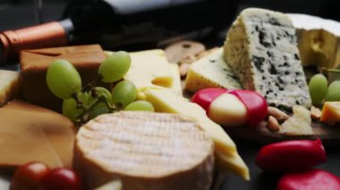 Peyniri üzümlerle, meyvelerle, peynir tabağıyla karıştır. Siyah arkaplanda şarap aperatifi.