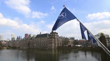 NATO Kuzey Atlantik Antlaşması Örgütü bayrakları, Hollanda 'nın Lahey kentindeki toprak setinde bayrak direkleri sallıyor
