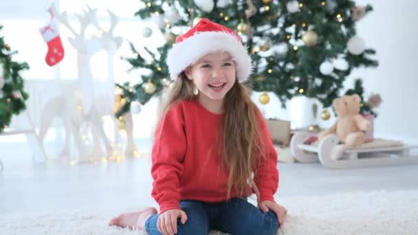 漂亮的小女孩在圣诞节的时候在家里微笑 在新年装点的房间里摆满了喜庆的树 漂亮的孩子 — 图库视频影像