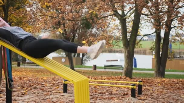 Fitness Mädchen Beim Bauchtraining Das Die Beine Herbst Park Hebt — Stockvideo