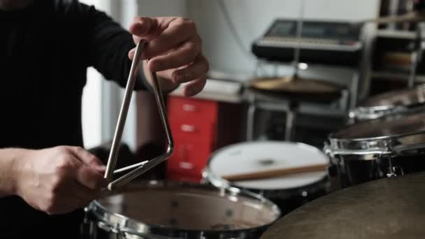 人的手在音乐三角形上弹奏 用金属棒和等待的声音敲打 在录音室用传统乐器的音乐家 — 图库视频影像