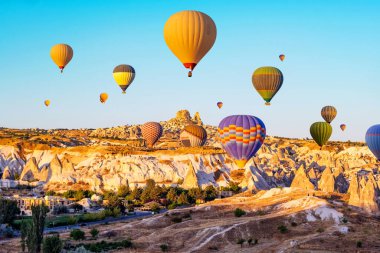 Kapadokya, Türkiye 'de günbatımında renkli sıcak hava balonları. Tarihi vadi ve antik şehir Goreme 'in muhteşem manzarası