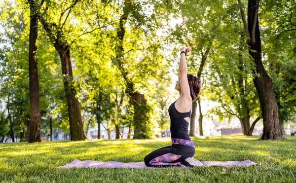 女孩在户外公园做瑜伽和伸展身体 在阳光灿烂的日子里在大自然中锻炼的年轻女子 — 图库照片