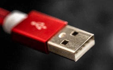 Akıllı telefon için kırmızı USB bağlantısı ve siyah arka planda yakın plan cihazlar. Mobil aygıtlar için makro kablo takın