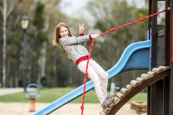 面白い女の子遊び場でロープで遊ぶ — ストック写真