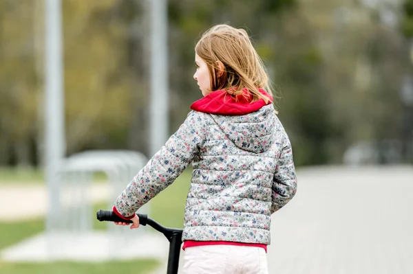 Pequena Menina Bonito Montando Uma Scooter Caminho Parque Visão Traseira — Fotografia de Stock