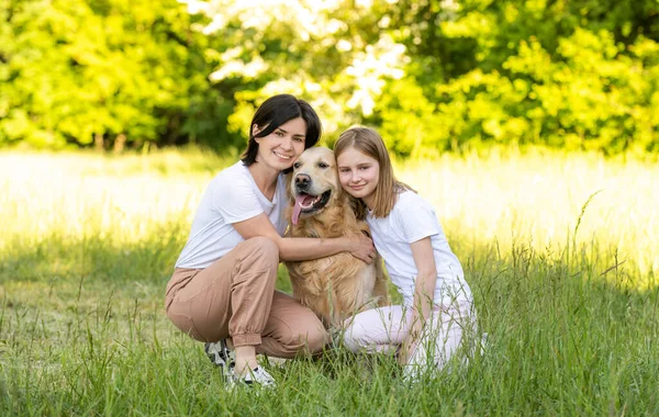 Anne Tatlı Kız Dışarıda Sevimli Golden Retriever Köpeğiyle Sarılıyorlar — Stok fotoğraf