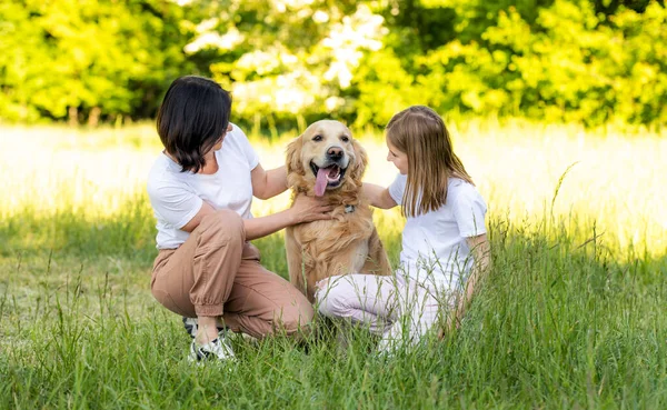 Anne Tatlı Kız Dışarıda Sevimli Golden Retriever Köpeğiyle Sarılıyorlar — Stok fotoğraf