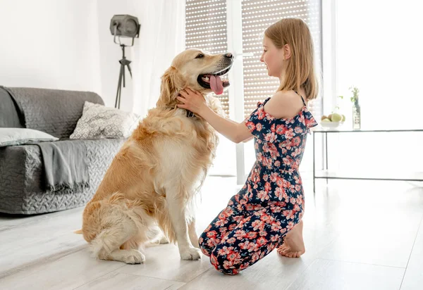 Милая Маленькая Девочка Играет Красивой Собакой Годен Ретривер Дома — стоковое фото