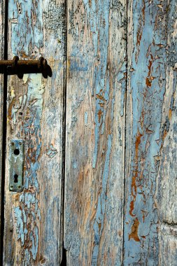 Eski ahşap kapılı arka planda eski turkuaz yüzey detayları var. Yıpranmış eski kırsal kereste