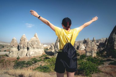 Kapadokya 'daki Türk dağlarında elini kaldırmış bir kadın turist.