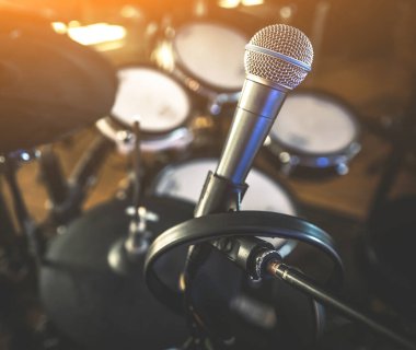 Microphone and drums in recording studio for live music perfomance closeup. Mic stage for rock and pop vocal presentation