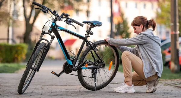 Молода Дівчина Перевіряє Тиск Велосипедних Шин Осінньому Парку — стокове фото