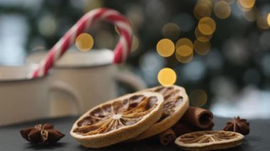 Dried lemon slices near anise star and cinnamon sticks with christmas cane candy on background