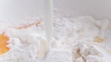 Ev yapımı ekmek hazırlamak için yumurta ve tahıl ununa süt eklemek. Pasta fırını için organik malzemeleri karıştırıyorum.